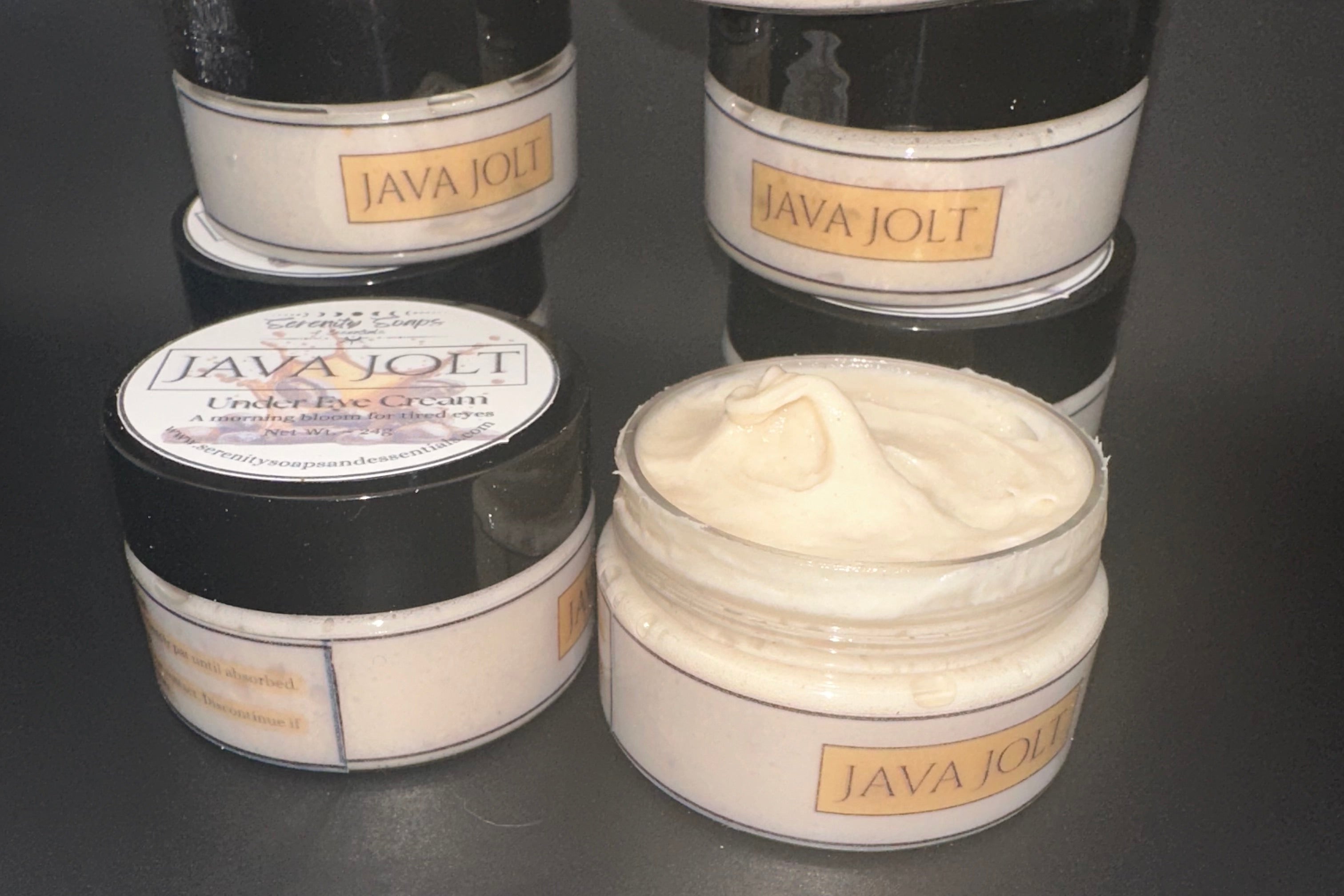 Jars of Java Jolt cream on a dark surface