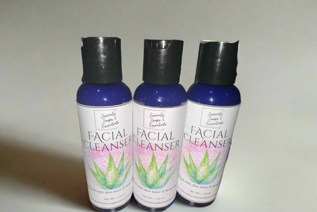 Three bottles of facial cleanser with aloe vera graphics on labels against a plain background.